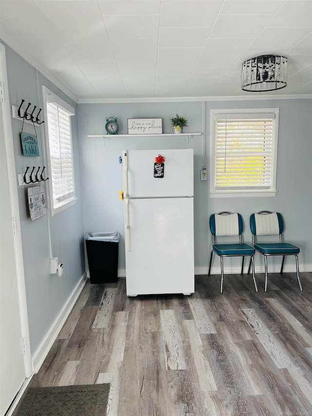 interior space with hardwood / wood-style flooring, a healthy amount of sunlight, and crown molding