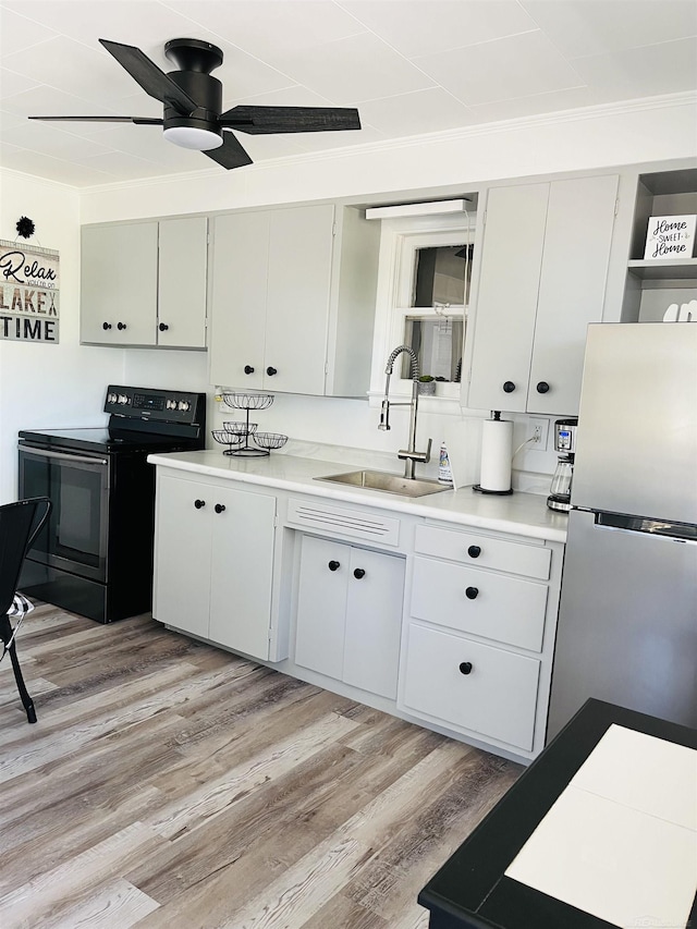 kitchen with stainless steel fridge, light hardwood / wood-style flooring, sink, and black electric range