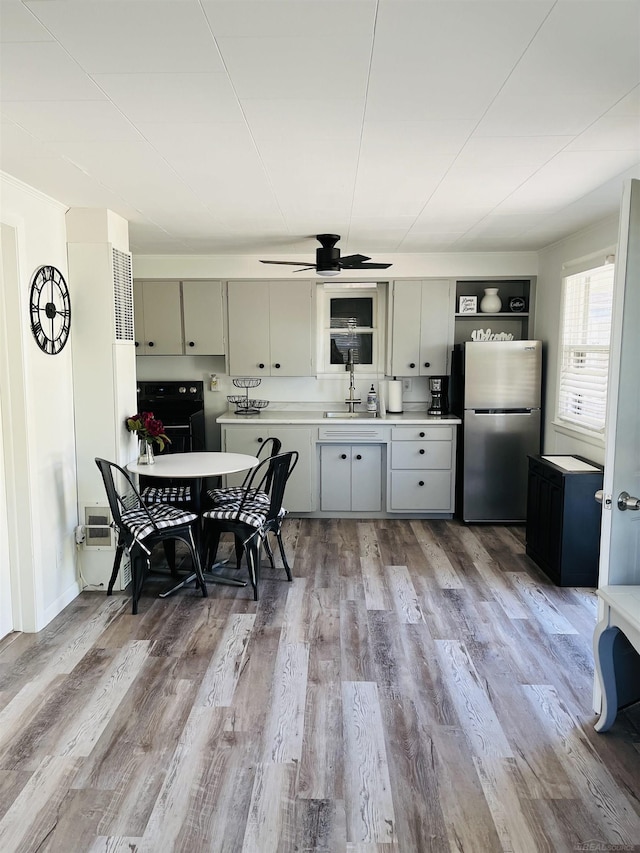 kitchen with sink, light hardwood / wood-style flooring, ceiling fan, gray cabinets, and stainless steel fridge