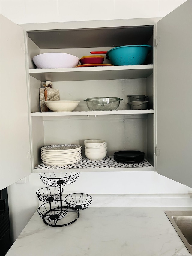 room details featuring light stone countertops and white cabinets