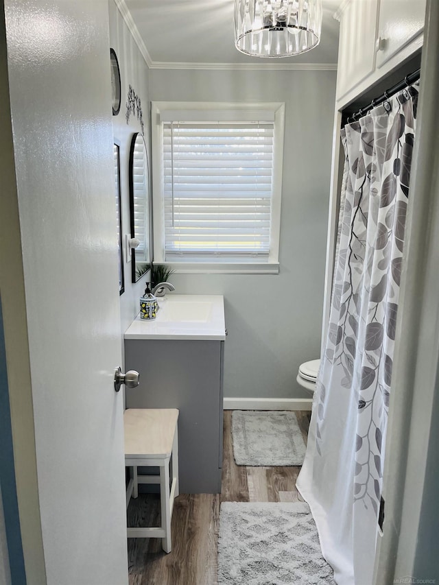 bathroom with hardwood / wood-style flooring, vanity, toilet, and crown molding