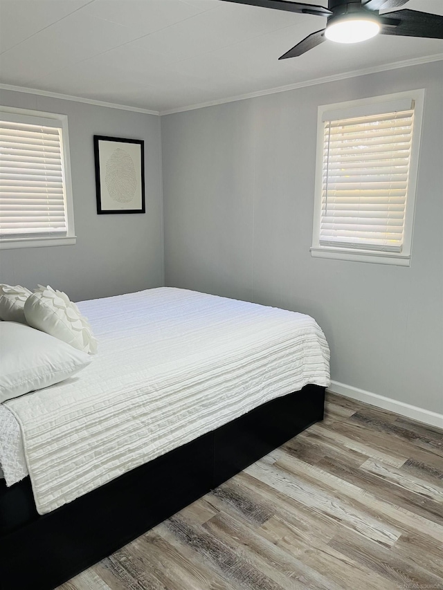 bedroom featuring hardwood / wood-style floors, ceiling fan, and crown molding