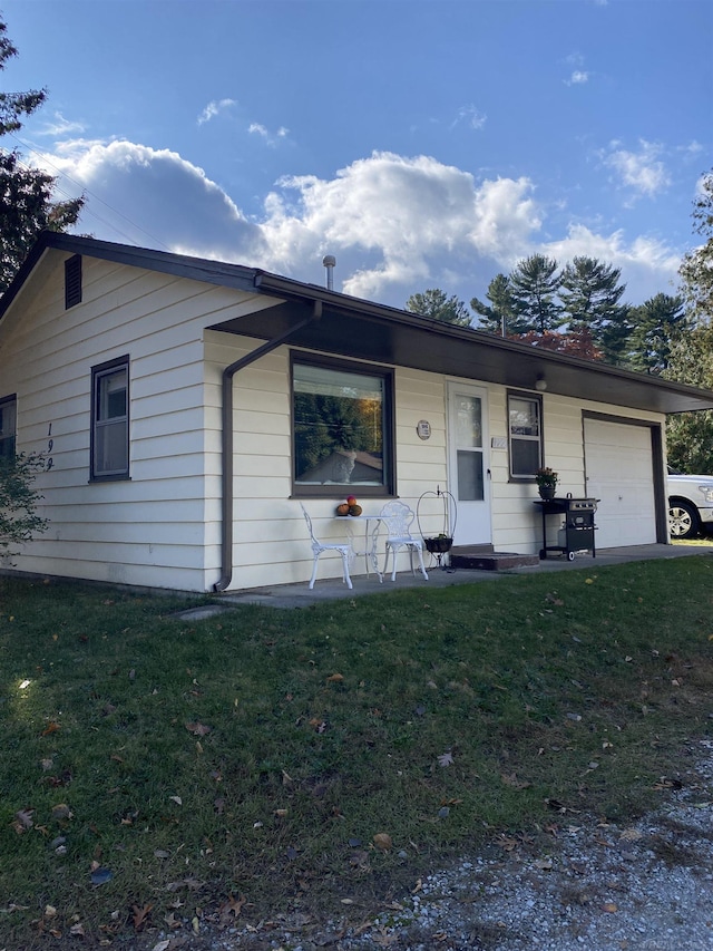 single story home with covered porch, a front yard, and a garage