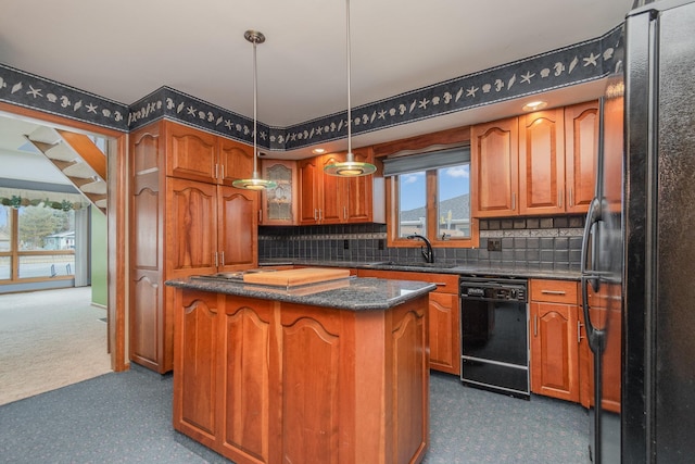 kitchen featuring black appliances, hanging light fixtures, decorative backsplash, a kitchen island, and sink