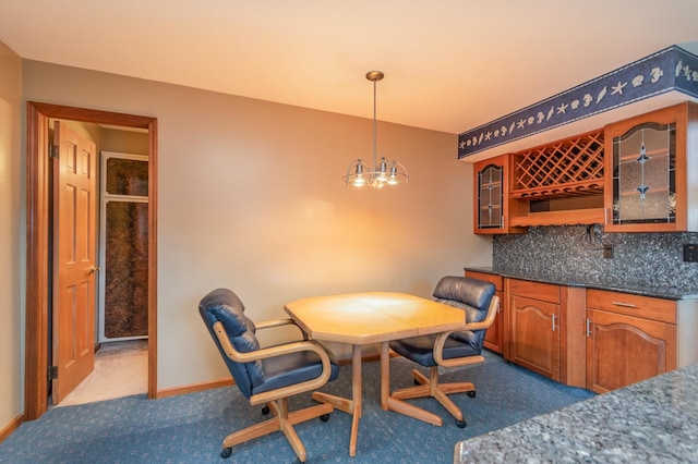 carpeted dining area with a chandelier