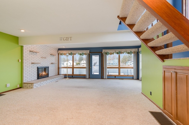 unfurnished living room featuring light colored carpet and a brick fireplace