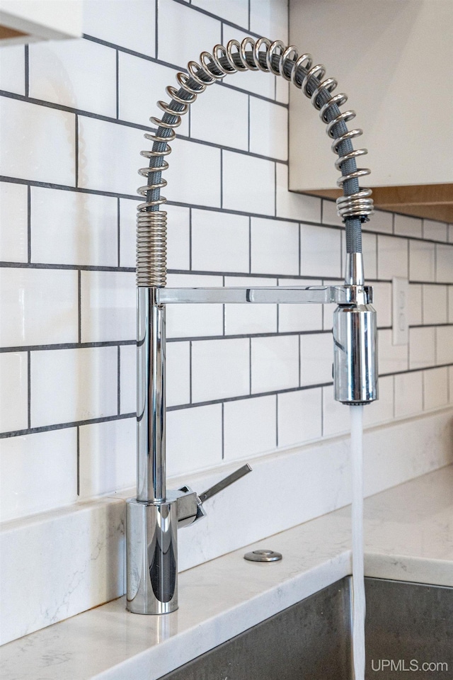 room details featuring decorative backsplash and sink