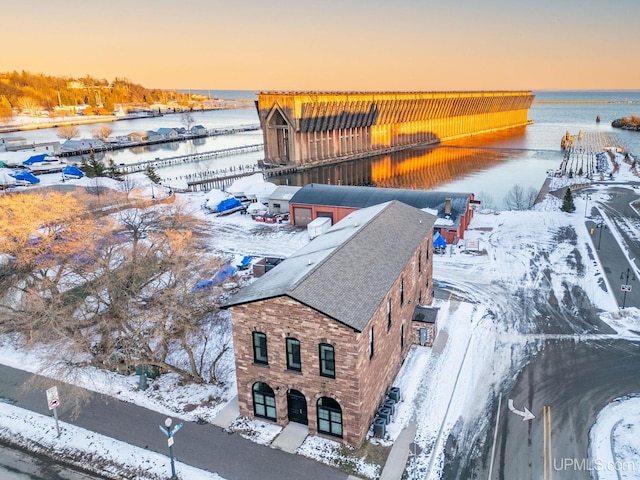 snowy aerial view with a water view