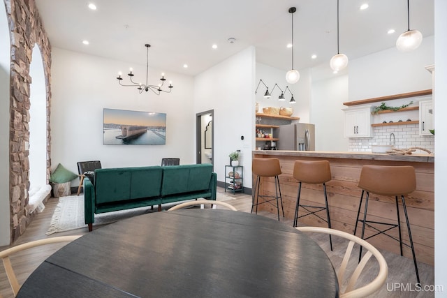 dining space featuring light wood-type flooring and an inviting chandelier