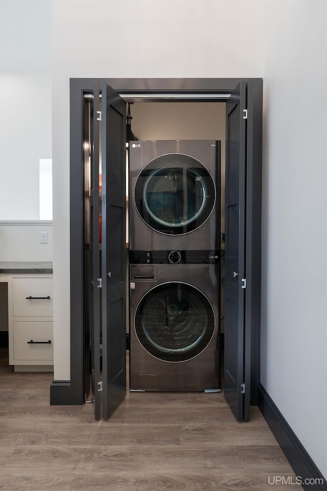 washroom featuring light hardwood / wood-style floors and stacked washer and clothes dryer