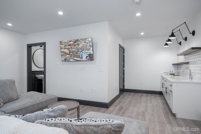 living room with light hardwood / wood-style floors and sink