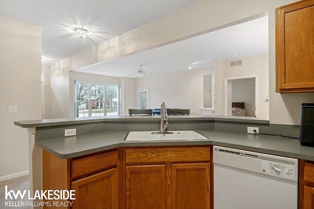 kitchen with white dishwasher, kitchen peninsula, ceiling fan, and sink