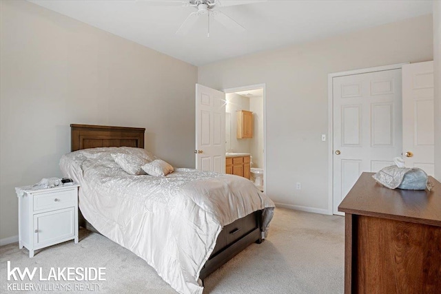 carpeted bedroom with ensuite bath and ceiling fan