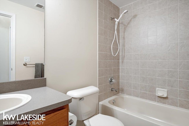 full bathroom featuring toilet, tiled shower / bath, and vanity