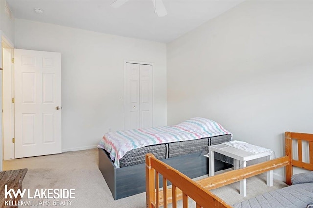 carpeted bedroom featuring ceiling fan and a closet