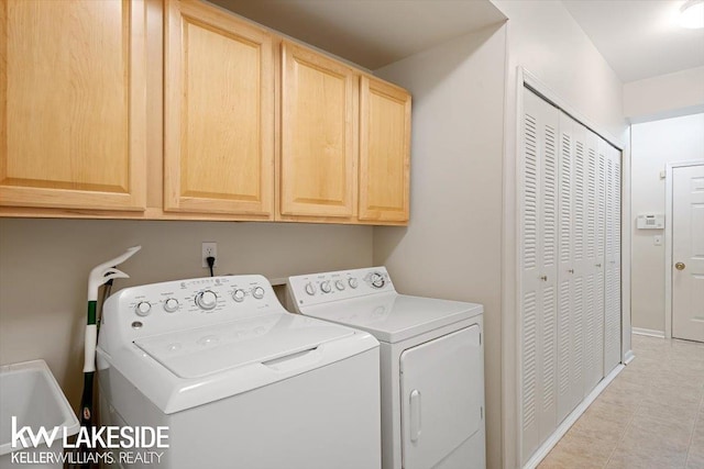 washroom featuring sink, washing machine and clothes dryer, and cabinets