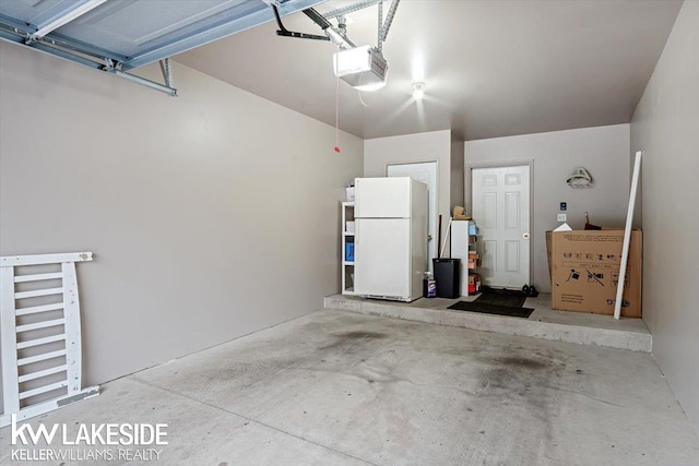 garage featuring white fridge and a garage door opener