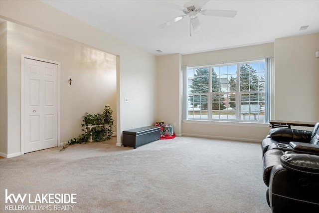 carpeted living room with ceiling fan