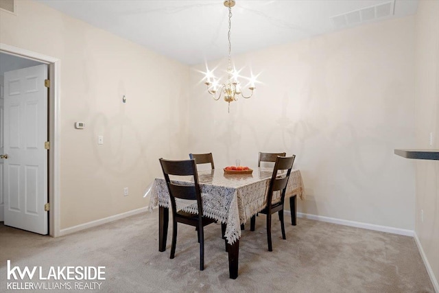 dining area with light carpet and a chandelier