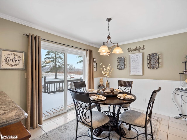 dining area with light tile patterned flooring, crown molding, and a notable chandelier