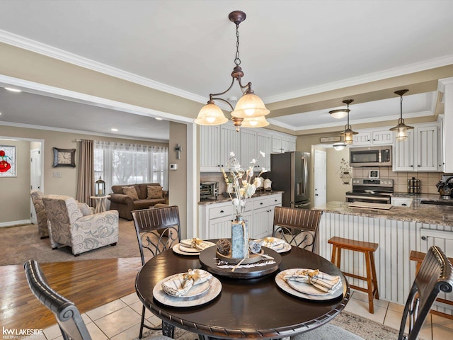 tiled dining room with a chandelier, ornamental molding, and sink