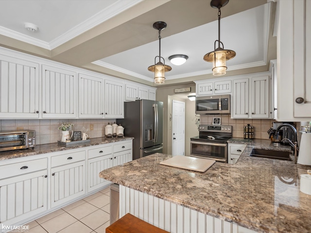 kitchen with decorative light fixtures, decorative backsplash, sink, stainless steel appliances, and white cabinets