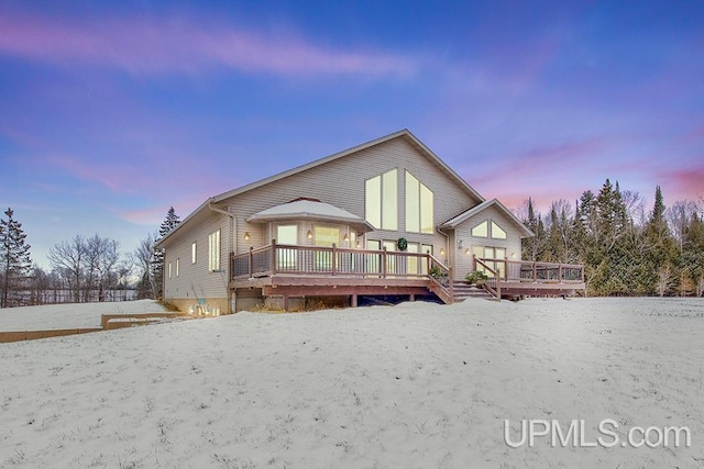 snow covered rear of property featuring a wooden deck and a gazebo