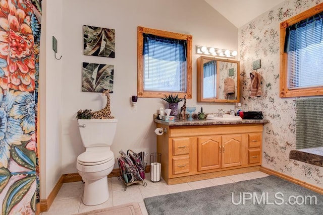 bathroom with vanity, vaulted ceiling, tile patterned floors, and toilet