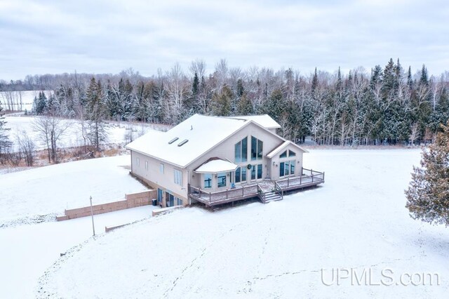 snow covered house featuring a deck