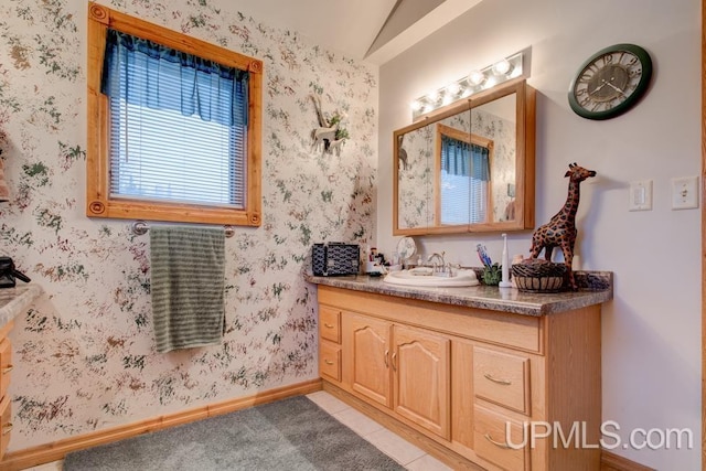 bathroom with tile patterned floors, lofted ceiling, and vanity