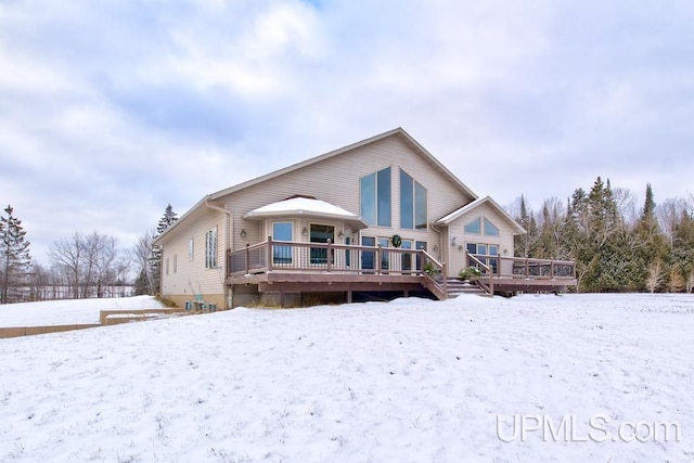 snow covered house with a wooden deck