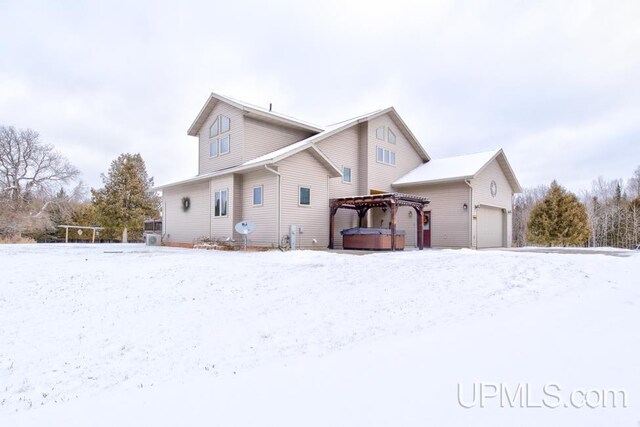 snow covered house with a hot tub and a gazebo