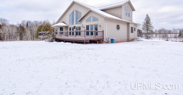 snow covered rear of property featuring central air condition unit and a deck