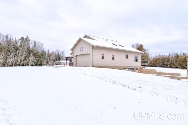 snow covered property featuring a garage