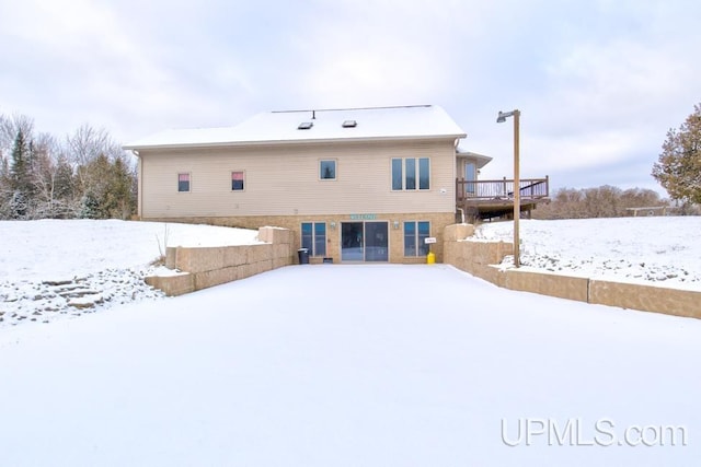 snow covered property with a deck