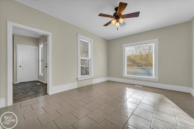 tiled spare room featuring ceiling fan