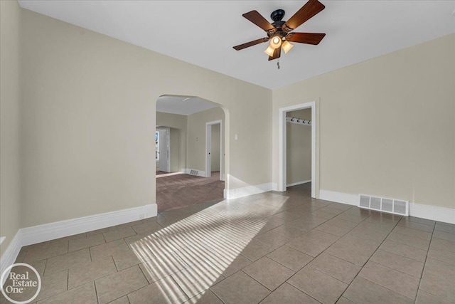 spare room featuring ceiling fan and tile patterned flooring