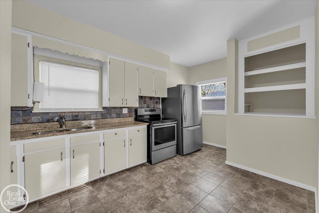 kitchen featuring backsplash, sink, white cabinetry, light stone countertops, and appliances with stainless steel finishes