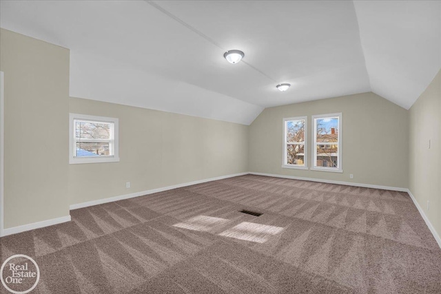 bonus room with vaulted ceiling and carpet flooring