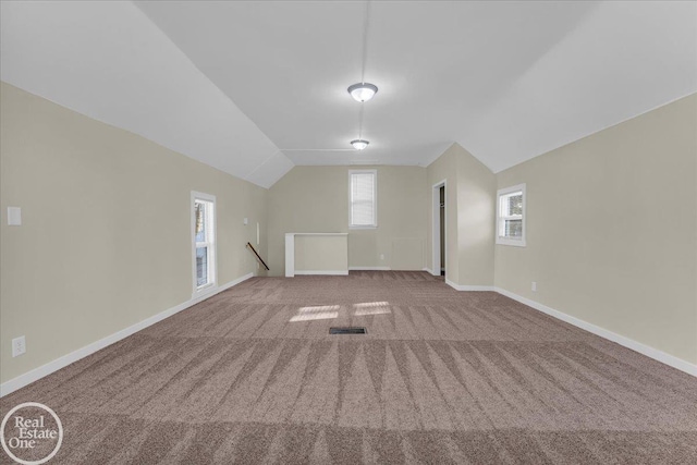 bonus room with vaulted ceiling and carpet floors