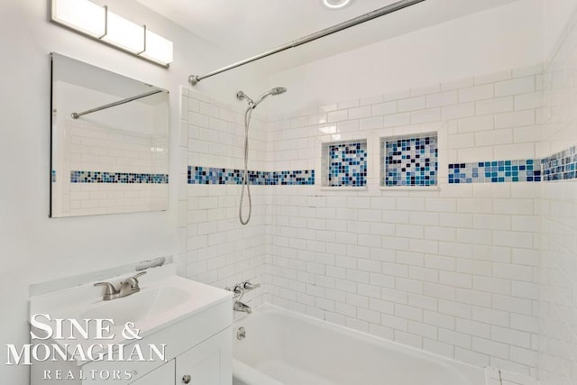 bathroom featuring vanity and tiled shower / bath