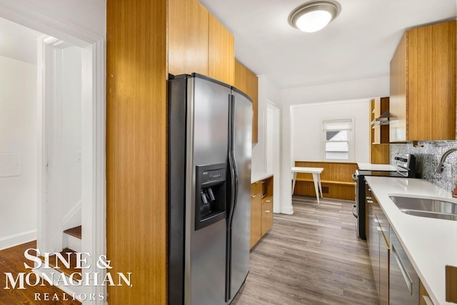 kitchen featuring appliances with stainless steel finishes, light hardwood / wood-style floors, and sink