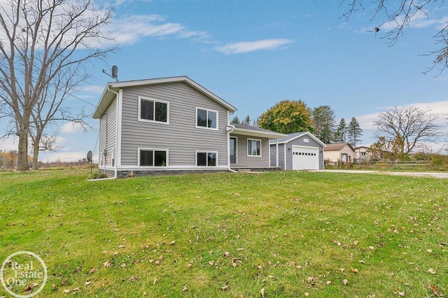 rear view of property with a yard and a garage