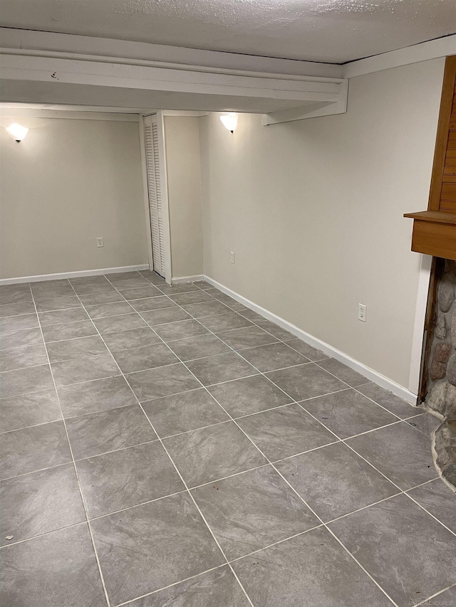 basement with tile patterned floors and a textured ceiling