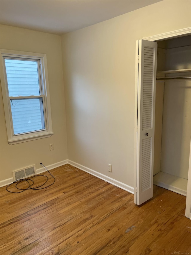 unfurnished bedroom with a closet and wood-type flooring