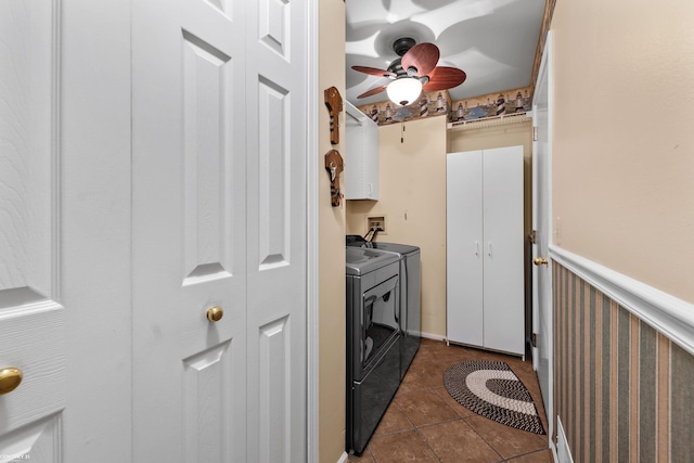 clothes washing area with ceiling fan, cabinets, washing machine and clothes dryer, and dark tile patterned floors