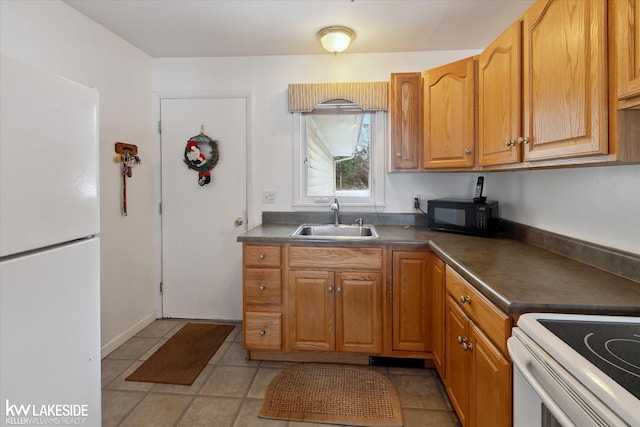 kitchen featuring white refrigerator, sink, and light tile patterned floors