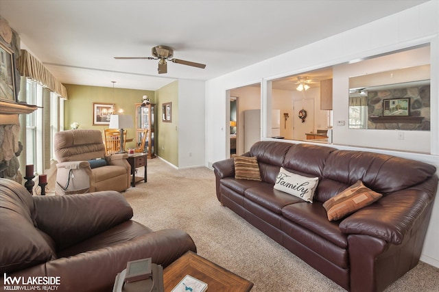 living room with ceiling fan with notable chandelier and light colored carpet