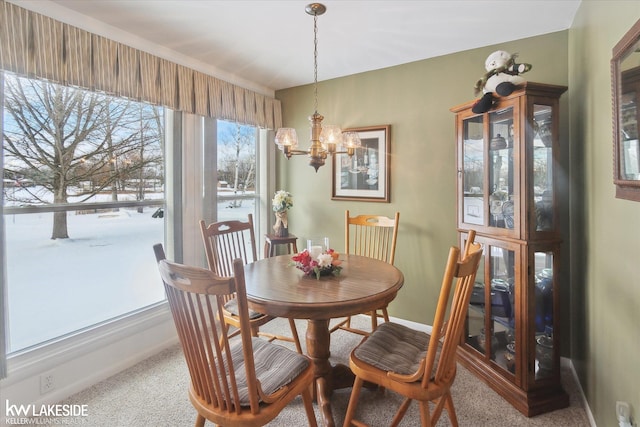 carpeted dining area featuring an inviting chandelier