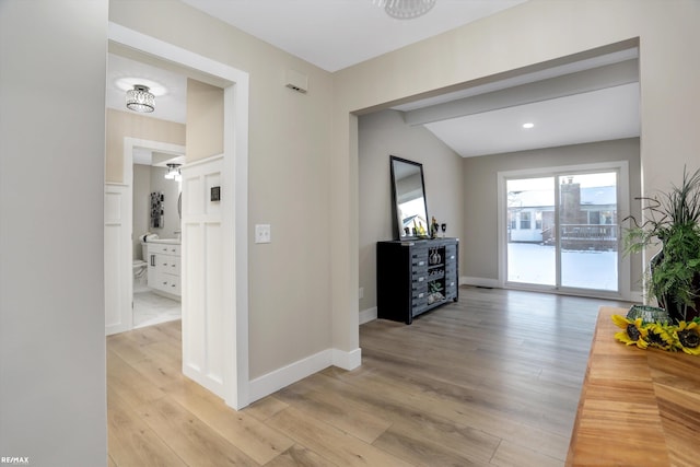 hall featuring lofted ceiling and light hardwood / wood-style floors